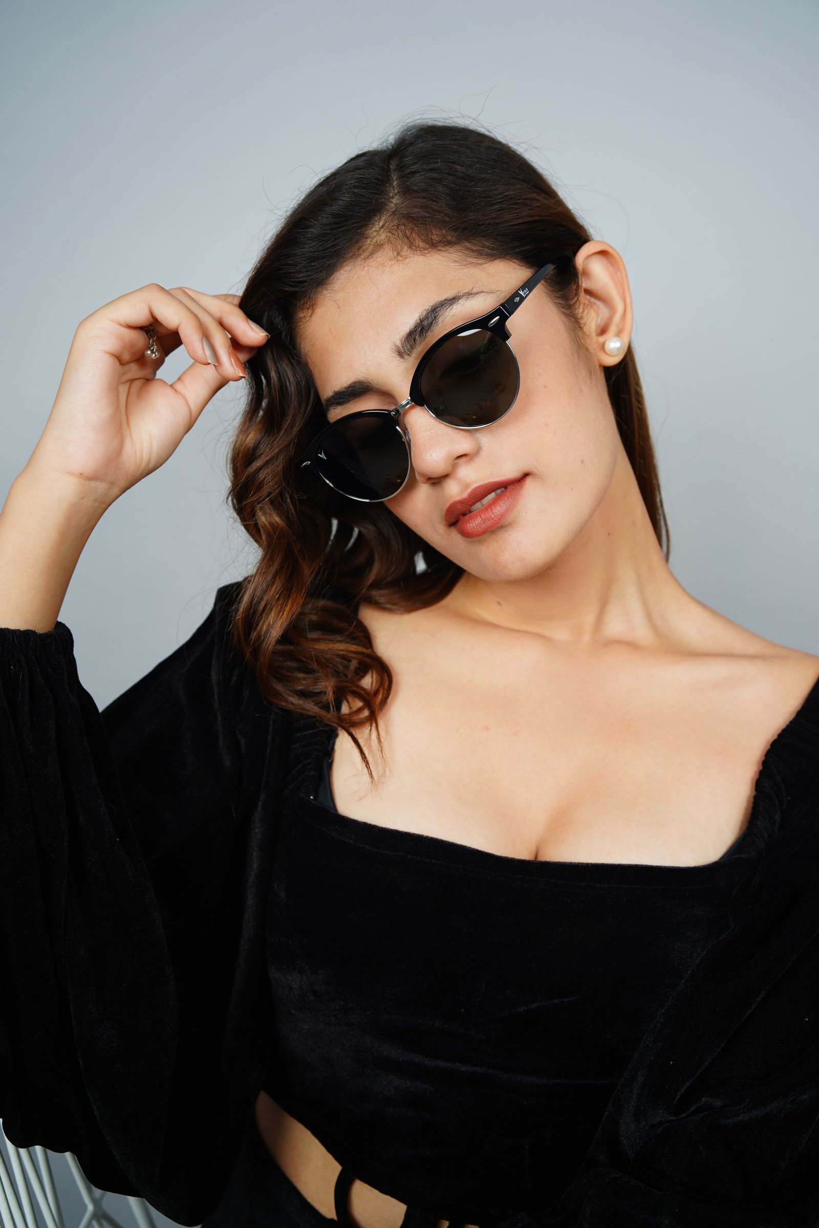 Sunglasses beside a garment rack for an e-commerce lookbook shoot